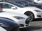 In this Sunday, March 15, 2020, photograph, a long row of unsold 2020 Model S sedans sit at a Tesla dealership in Littleton, Colo. (AP Photo/David Zalubowski)