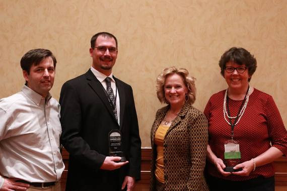 State Superintendent Jillian Balow stands with award winners in the banquet hall.