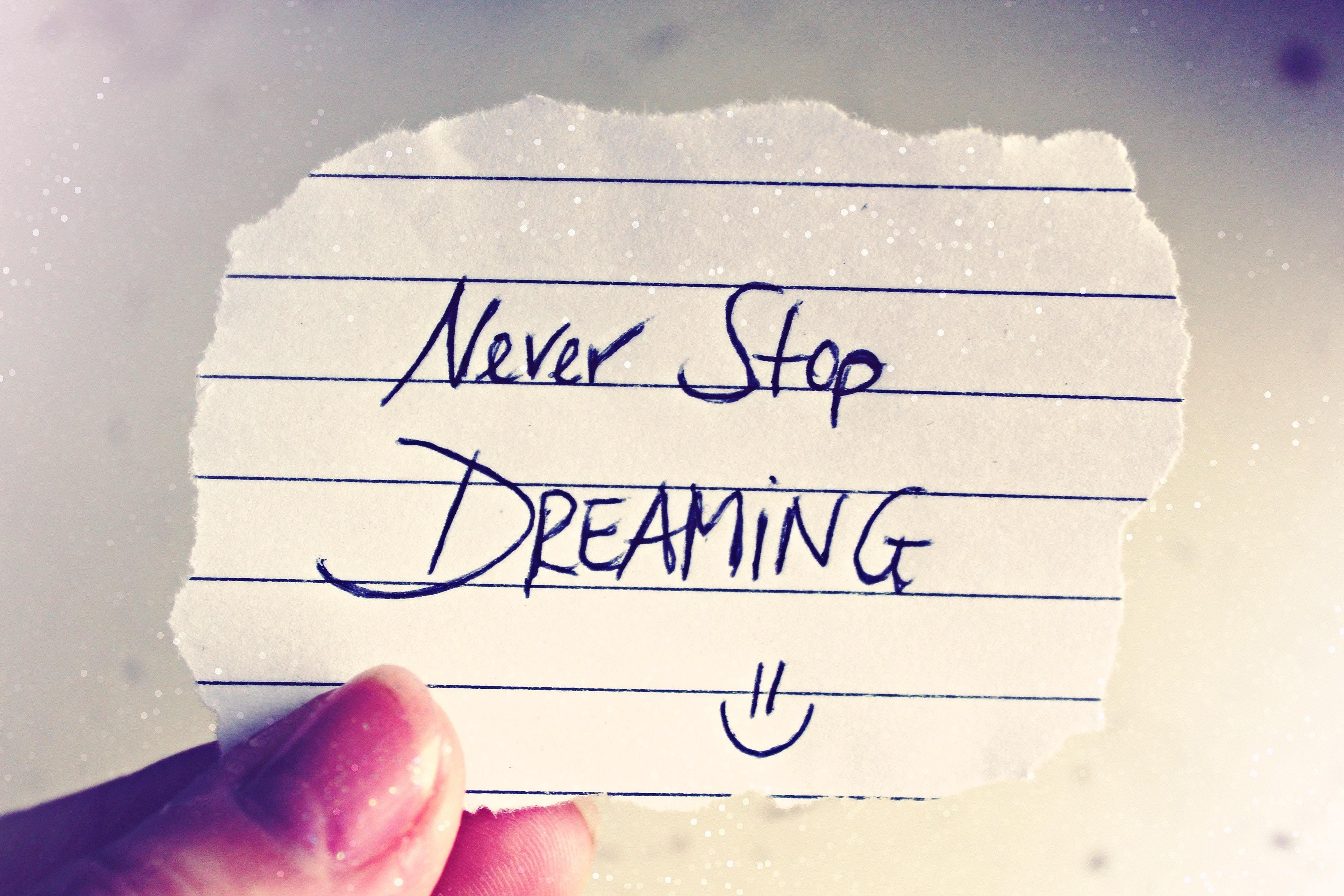 Held up note. Never Stop Dreaming.