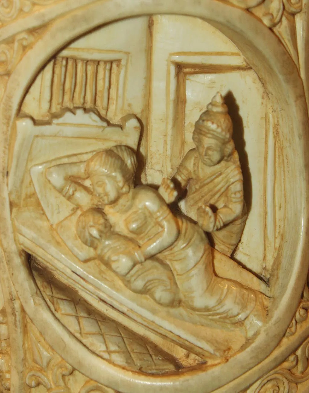 Ivory carving of Buddha leaving a woman and child sleeping in bed.