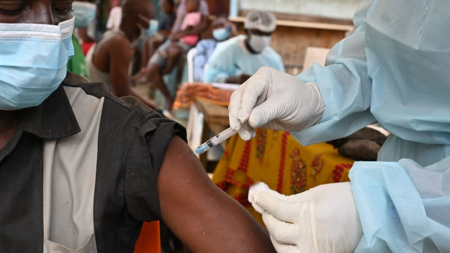 A health worker vaccinates a man in Abidjan on August 17, 2021 during a roll-out of vaccinations against Ebola on August 17, 2021, after the country recorded its first known case of the disease since 1994. (Photo by Issouf SANOGO / AFP) (Photo by ISSOUF SANOGO/AFP via Getty Images)