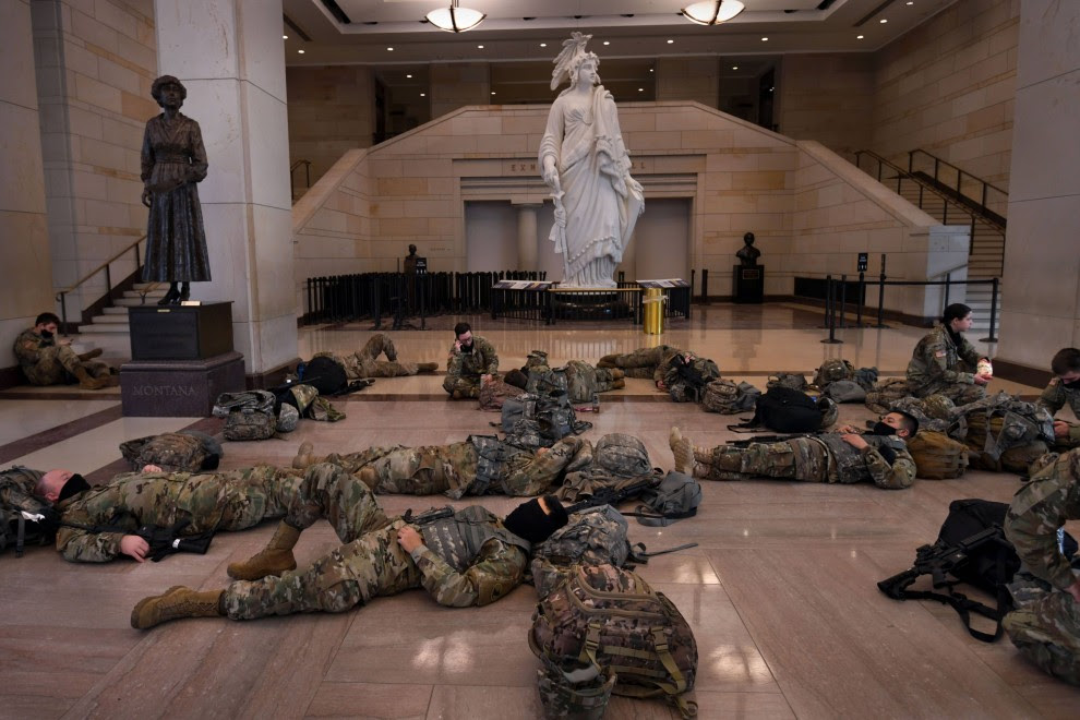 Las tropas de la Guardia Nacional descansan dentro del Capitolio de los Estados Unidos mientras protegen el edificio antes de la próxima toma de posesión del presidente electo Joe Biden.