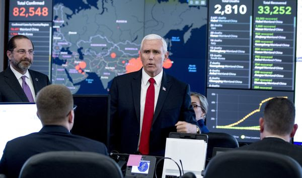 A large monitor displaying a map of Asia and a tally of total coronavirus cases, deaths, and recovered, is visible behind Vice President Mike Pence, center, and Health and Human Services Secretary Alex Azar, left, as they tour the Secretary&#39;s Operations Center following a coronavirus task force meeting at the Department of Health and Human Services, Thursday, Feb. 27, 2020, in Washington. (AP Photo/Andrew Harnik)