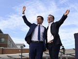 Democratic presidential candidate former South Bend, Ind., Mayor Pete Buttigieg, left, and his husband Chasten Buttigieg, right, wave to the crowd following a campaign event in Arlington, Va., Sunday, Feb. 23, 2020. (AP Photo/Susan Walsh)