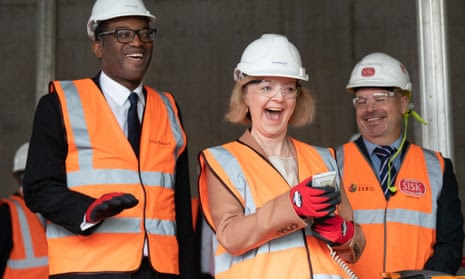 Kwasi Kwarteng stands behind an elated Liz Truss wielding machinery controls on a Birmingham construction site during the Conservative party conference