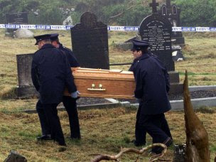 Irish police remove a coffin with the remains of Eamon Molloy from a cemetery in 1999