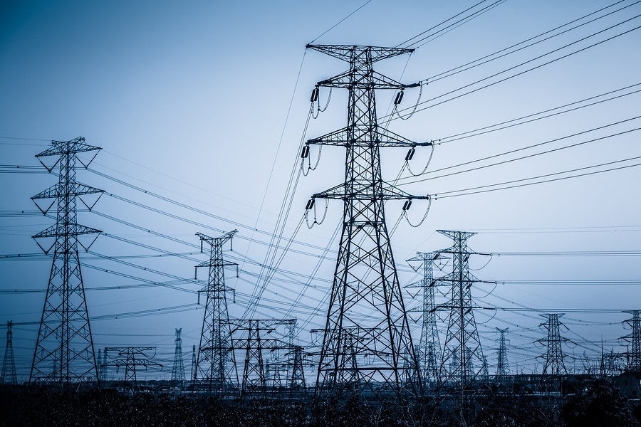 High voltage towers with sky background.