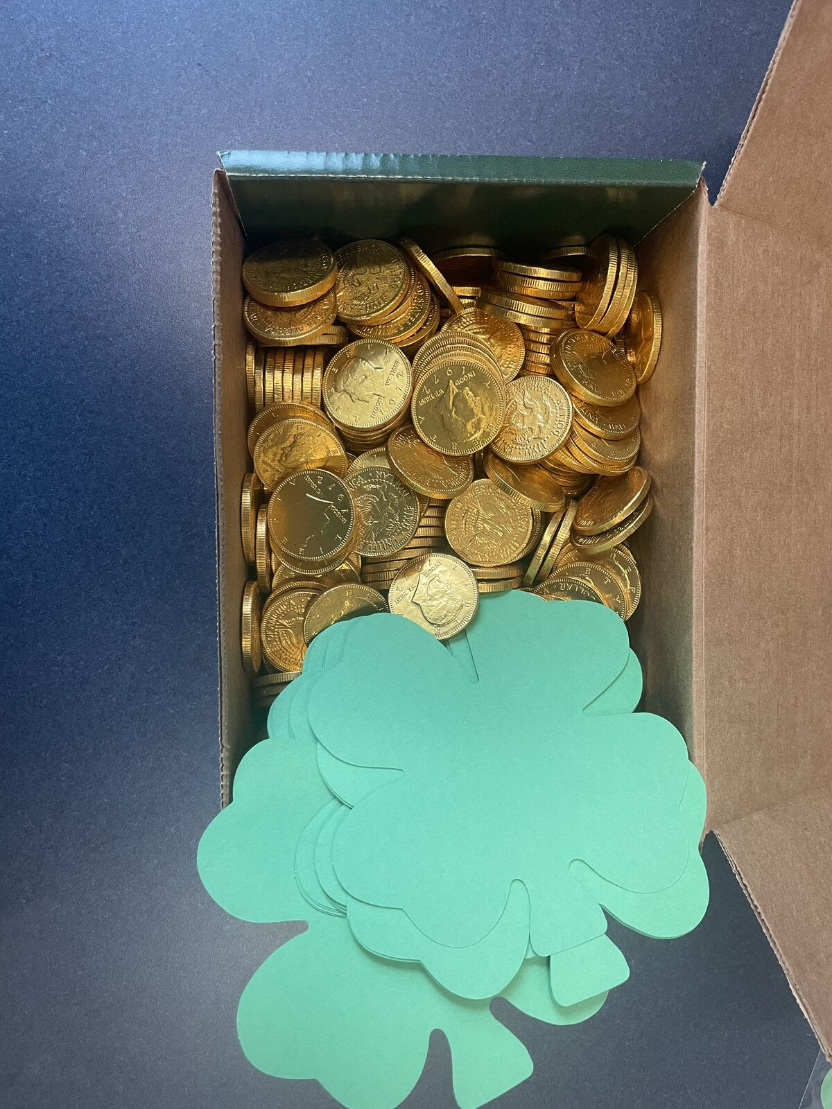 box of gold candy coins and shamrock cutouts