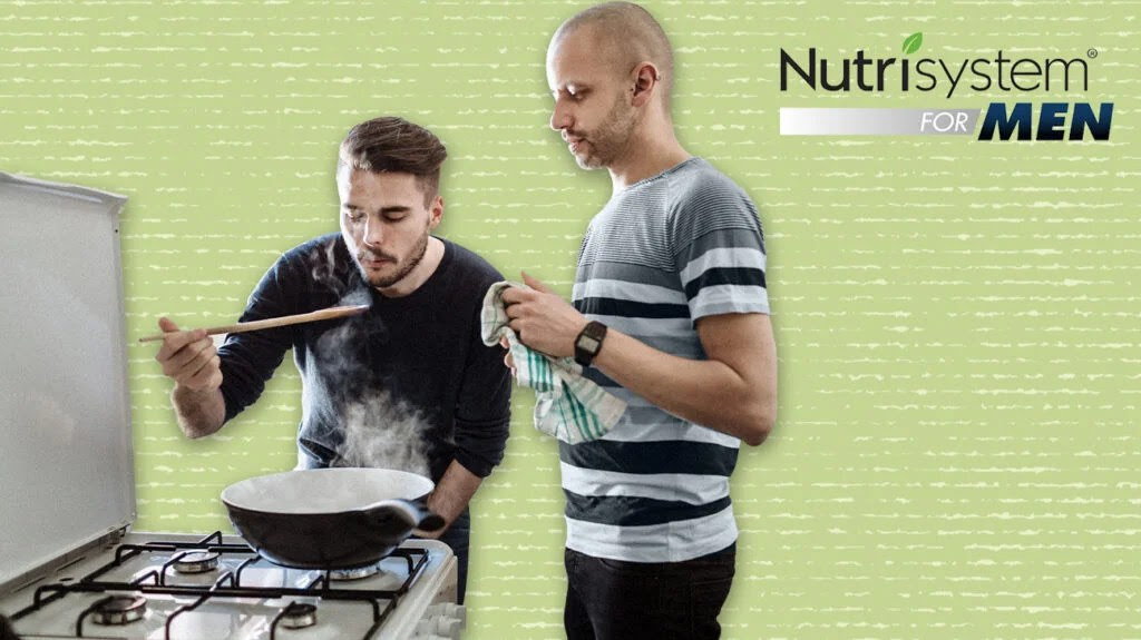 Man on a cycling machine while a personal trainer watches next to Nutrisystem for men logo isolated over pale green background