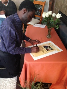 Signing President Sata's book of condolences at Mr & Mrs Mate's residence in Cochrane, AB, Canada