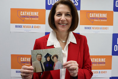 Catherine Cortez Masto holding a photo from graduation