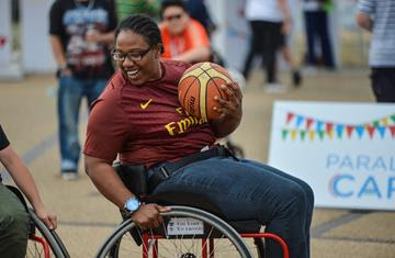 A woman in a wheelchair basketball chair with a ball in her hands