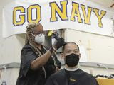 Kenneth Nguyen, 18, from Portland, Oregon, gets his hair cut by hairstylist Lisa Rivera as incoming freshman midshipmen, or plebes, arrive at the United States Naval Academy in Annapolis Tuesday, to begin their Plebe Summer of training during a COVID-19 modified Induction Day. (Paul W. Gillespie/The Baltimore Sun via AP)