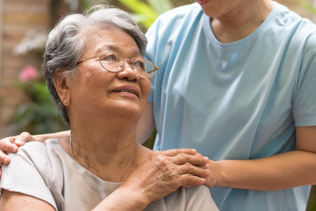 a daughter gently touches her mother shoulder