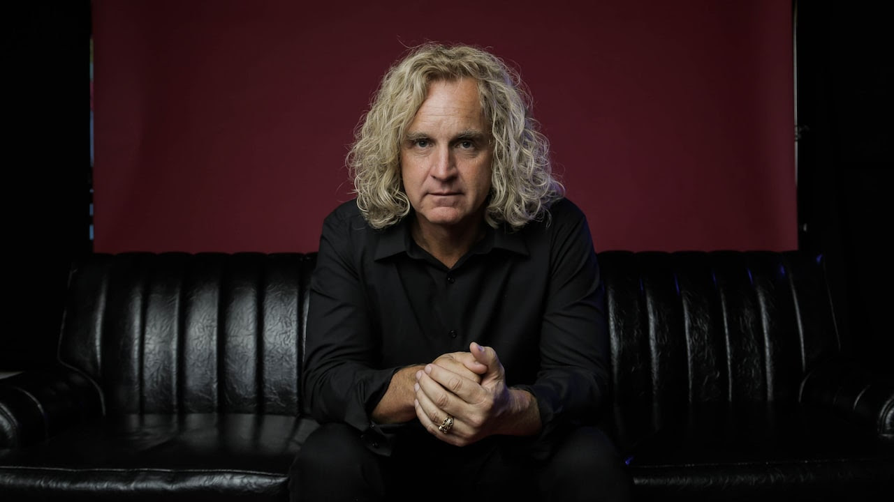 Bassist, singer and songwriter Jason Scheff seated on a couch
