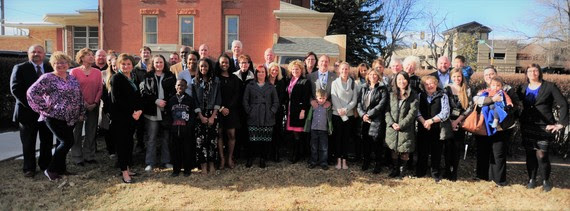 State Superintendent Jillian Balow and Governor Matt Mead pose for a photo behind the Governor's Office with several dozen people in support of adoption month.