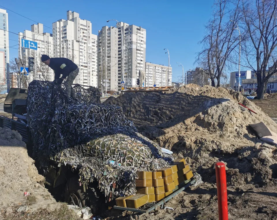 A Kyiv resident and volunteer prepares a rear post with trenches.