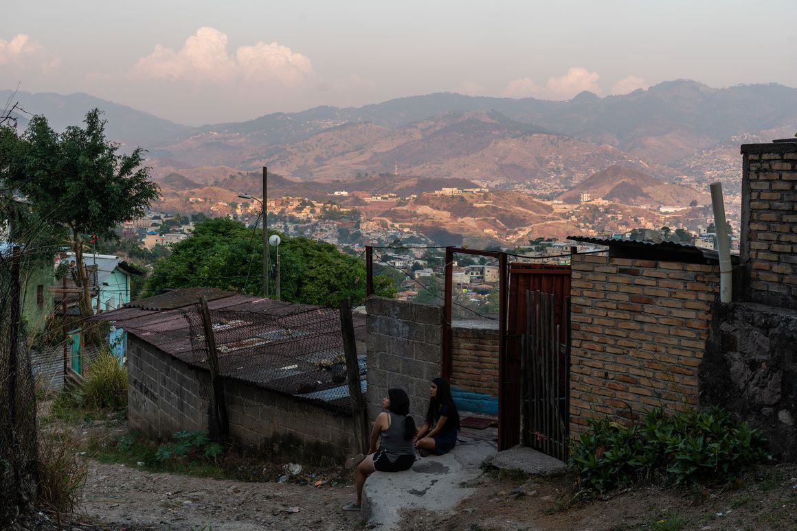 Women sit outside their home on the hills overlooking the city of Tegucigalpa.
