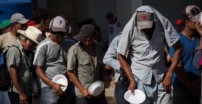 Integrantes de la caravana de migrantes centroamericanos que se dirigen a Estados Unidos hacen fila para recibir alimentos el municipio de Juchitán, en el estado de Oaxaca (México). - EFE