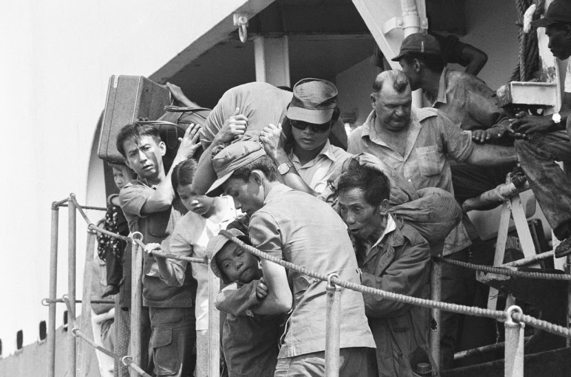South Vietnamese refugees disembark at Cam Ranh Bay in Vietnam, Saturday, March 30, 1975 on South Vietnam?s central coast following a voyage from Da Nang, the city which has since fallen to communist forces. Westerner at right is a member of the ship?s crew. (AP Photo/Nick Ut)