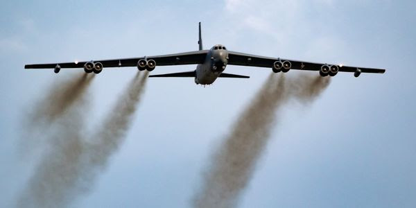 A U.S. military plane pours pollution out of its engines.
