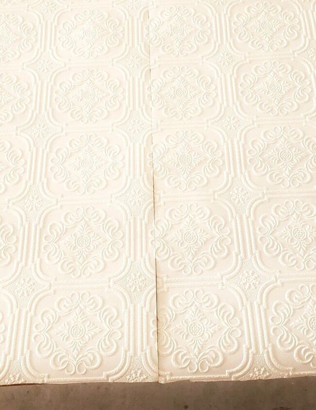 White patterned wallpaper cut down middle.