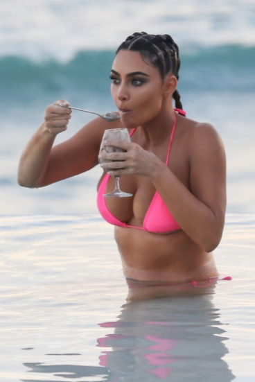 Kim Kardashain displays her curves in a skimpy pink bikini