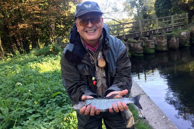 Andreas Topintzis, general manager of the Salisbury and District Angling Club in Britain, holds a grayling caught by a companion using a mop fly. Mr. Topintzis prefers using traditional flies.