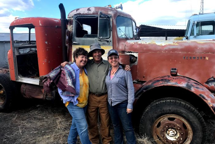 Becky Longberg and her parents standing by a farm truck.