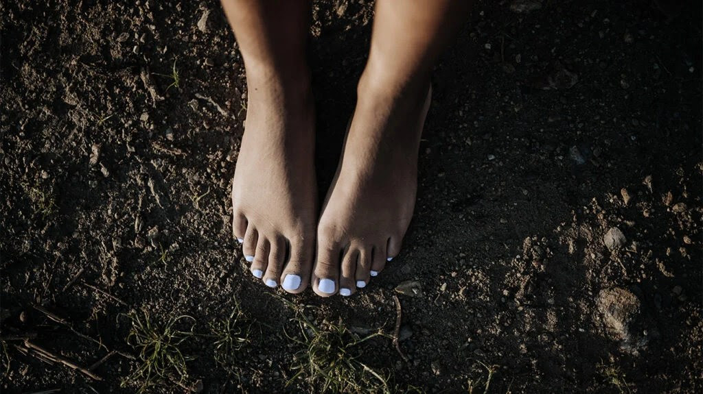 Closeup of feet in the grass.