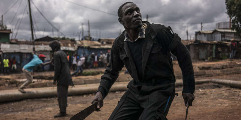 Un homme brandit une machette et un couteau lors d’affrontements avec les forces de l’ordre dans le quartier de Kibera, à Nairobi, lors de l’élection présidentielle kényane, le 26 octobre 2017.