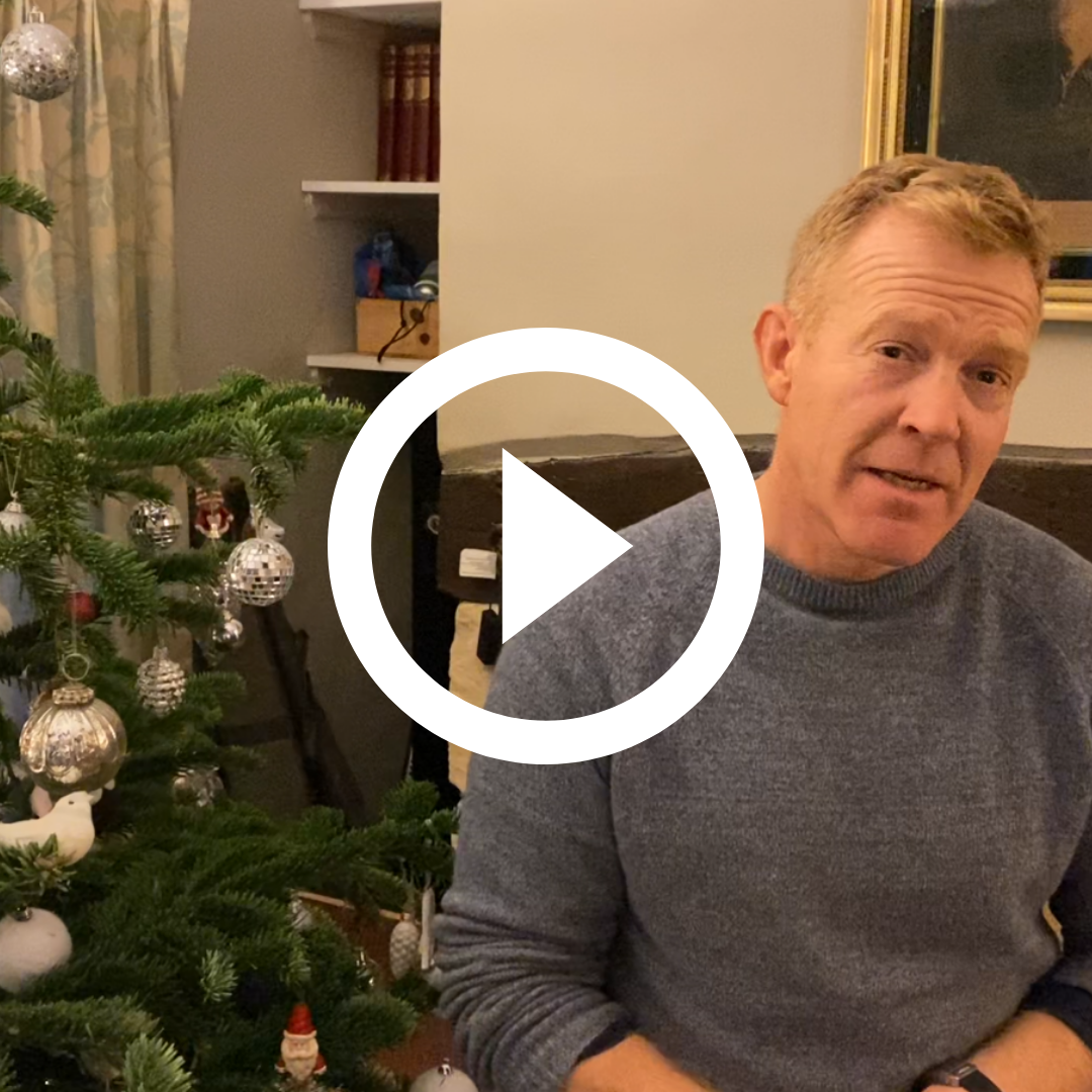 Video screenshot of Adam Henderson talking in front of Christmas tree