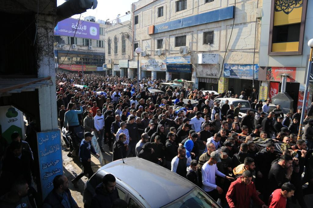 Crowds march in the streets to carry the bodies of the Palestinians killed on Thursday during an Israeli rai.d