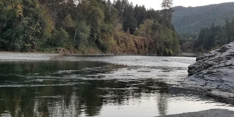 river running through steep, forested mountains