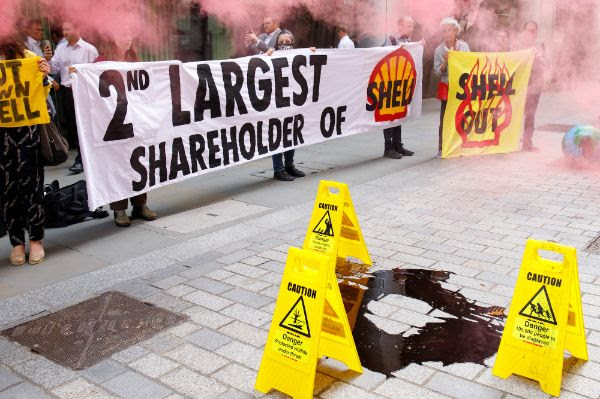 People holder a banner that reads 2nd largest shareholder of Shell, and Shell out