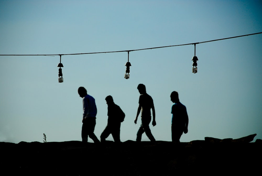 silhouette de personnes marchant dans la rue pendant le coucher du soleil