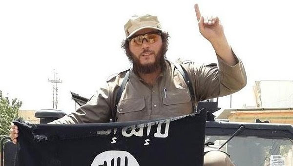 ISIS jihadist with                                                 ISIS flag and one-finger                                                 ISIS salute