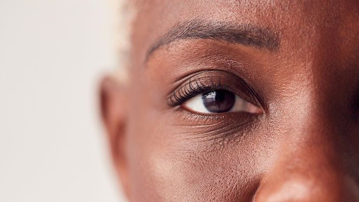 Close-up on a woman's eye. The background is plain white.