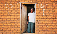 Small blog ug 459. abayudaya jew joseph mwanika in the doorway of a house nalubembe village kikubu district uganda. august 2013