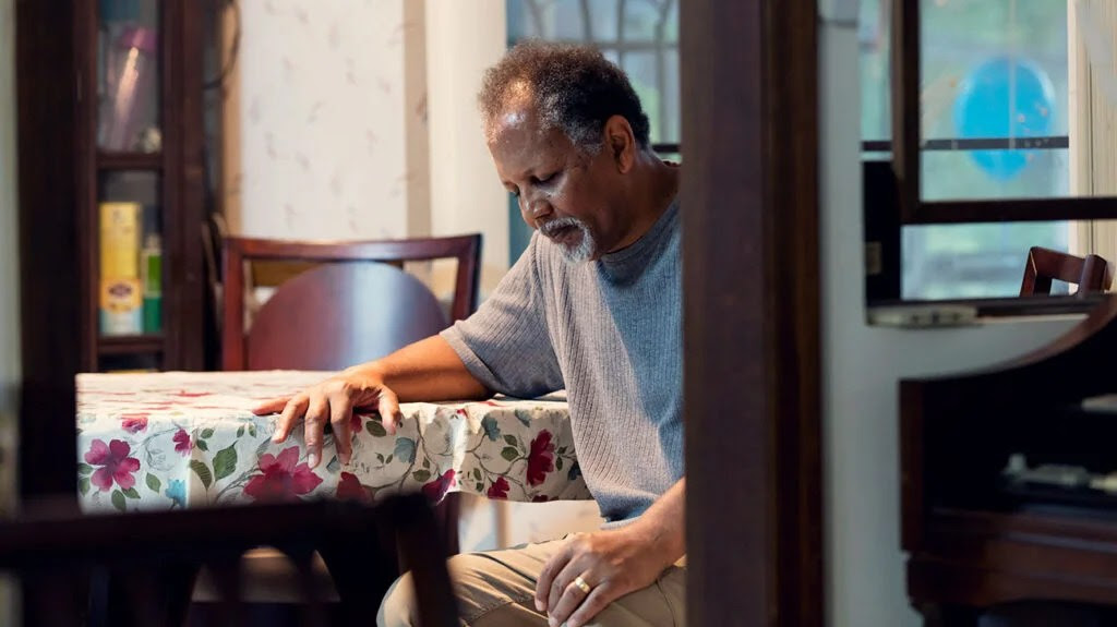 A man sitting down with shortness of breath, which is a common sign of renal failure.