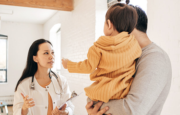 A father and toddler consulting with a doctor.