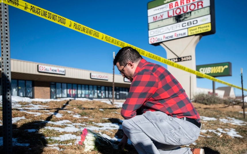 Jace Khosla, from Pueblo, Colorado, places flowers at the police tape surrounding Club Q