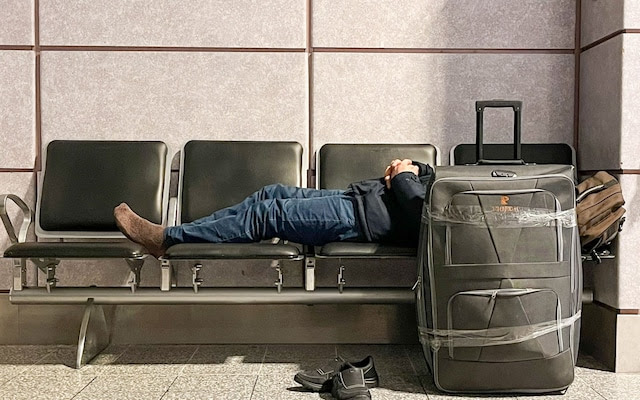 A passenger sleeping at Manchester Airport's Terminal 2