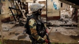 Un membre du bataillon camerounais d'élite d'intervention rapide (BIR) patrouille dans le village abandonné d'Elona, près de Buea, dans la région anglophone du sud-ouest du Cameroun, le 4 octobre 2018.