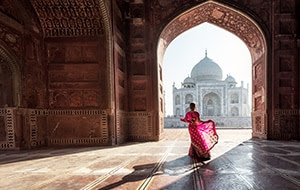 Woman standing in doorway looking at Taj Mahal