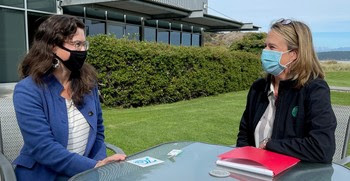 Photo of two people sitting at a table outside