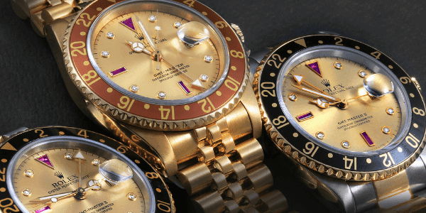 Rolex GMT-Master II Yellow Gold Steel Diamond Ruby Serti Dial Watch and Rolex GMT Master Vintage Yellow Gold Serti Diamond Ruby Watch (center)