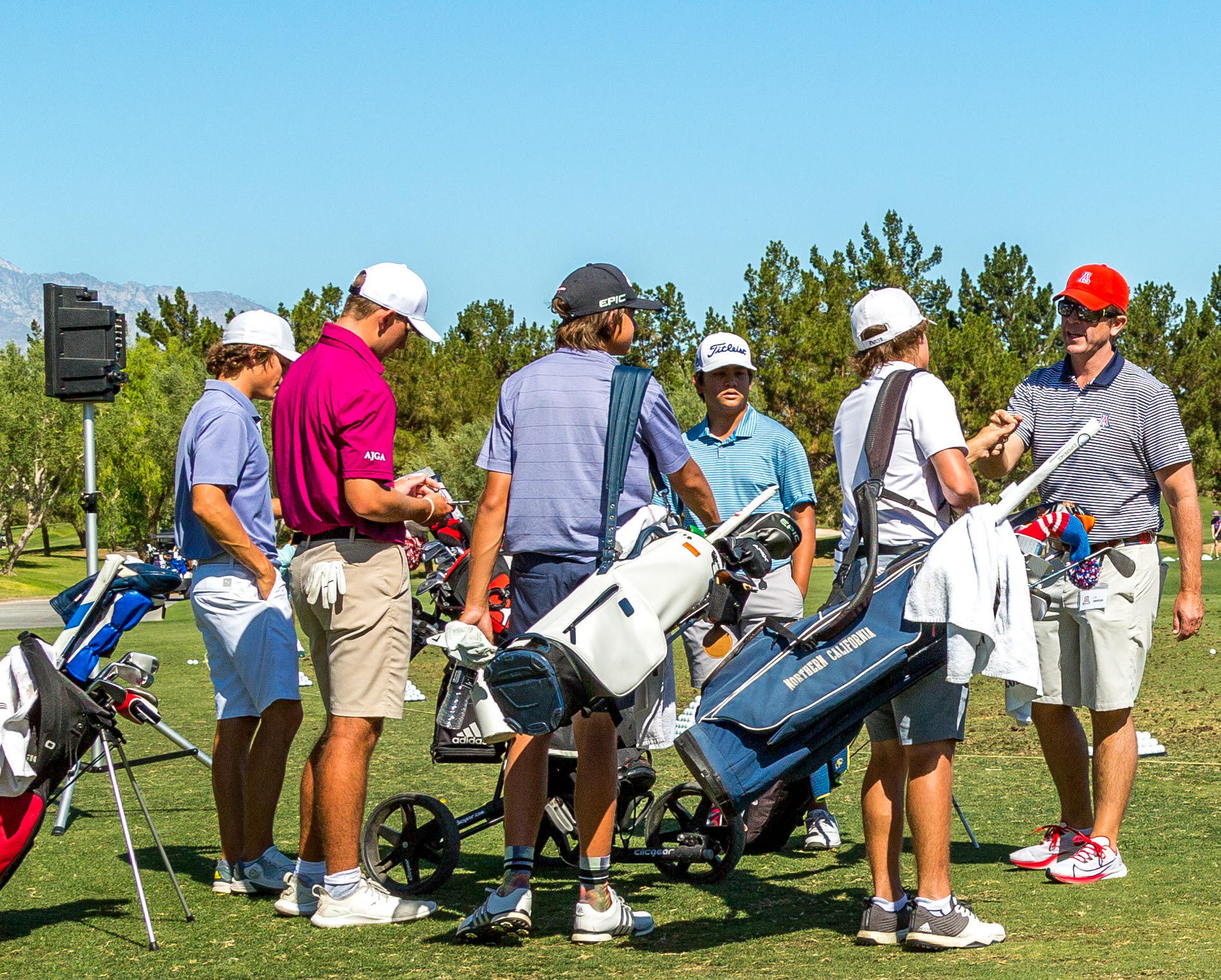 A group of people with golf clubs
Description automatically generated with medium confidence