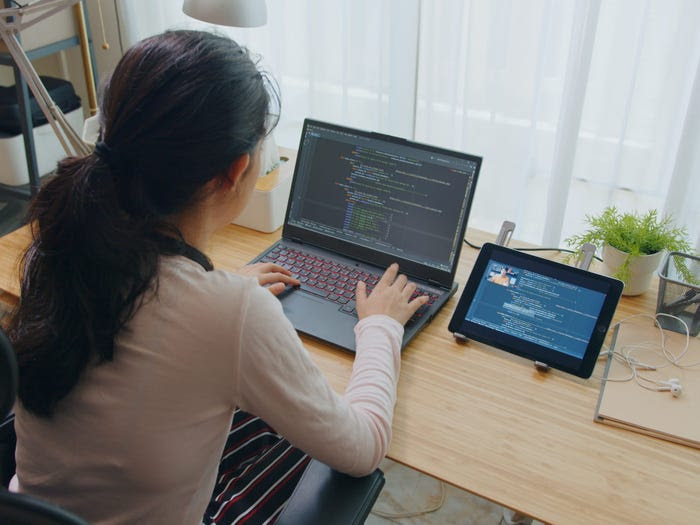 software developer coding on computer at desk at home