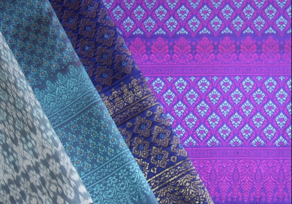 Look at the two narrow bands in the border design on the bottom of each of the three lengths of brocade (right of the aqua ikat). They’re known as Banteay Srei Stripes.
